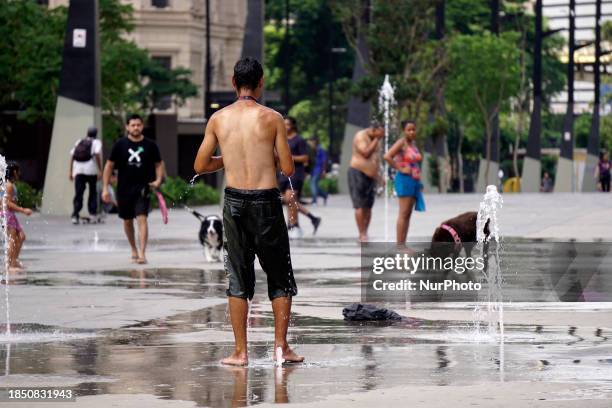 People are cooling off in the Anhangabau fountain during another heatwave in Sao Paulo, Brazil, on December 15, 2023.