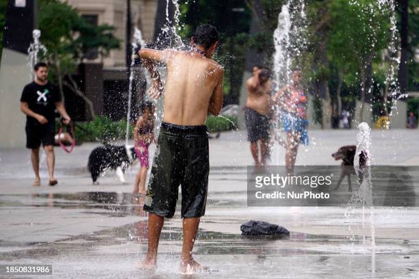 People are cooling off in the Anhangabau fountain during another heatwave in Sao Paulo, Brazil, on December 15, 2023.