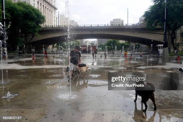 People are cooling off in the Anhangabau fountain during another heatwave in Sao Paulo, Brazil, on December 15, 2023.