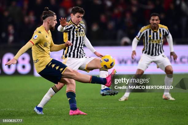 Genoa's Romanian defender Radu Dragusin fights for the ball with Juventus' Italian defender Andrea Cambiaso during the Italian Serie A football match...