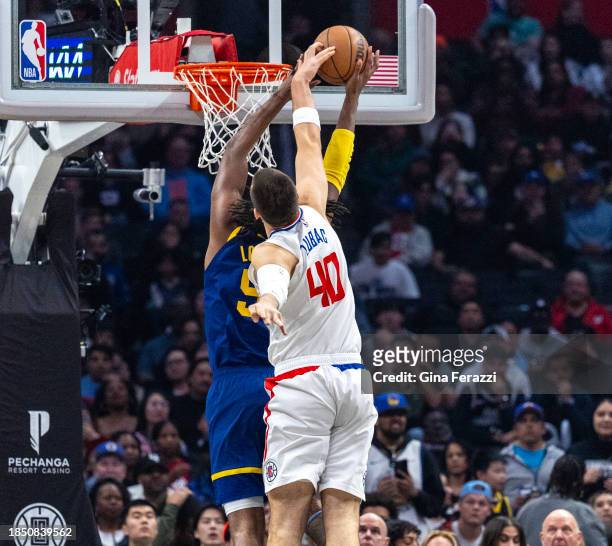 Clippers center Ivica Zubac blocks a shot by Golden State Warriors forward Kevon Looney in the first half at Crypto.com Arena on December 14, 2023 in...