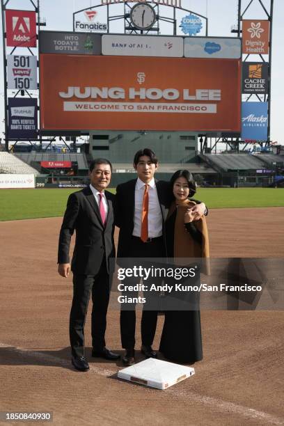 Jung Hoo Lee poses with his father Jong Beom Lee and mother Jung Min Jung on the field at Oracle Park before a press conference to introduce his...