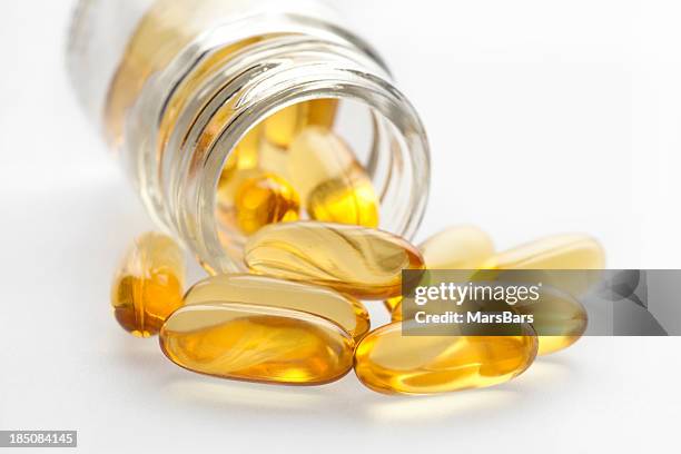 omega 3 fish oil capsules and bottle - antioxidant pill stock pictures, royalty-free photos & images