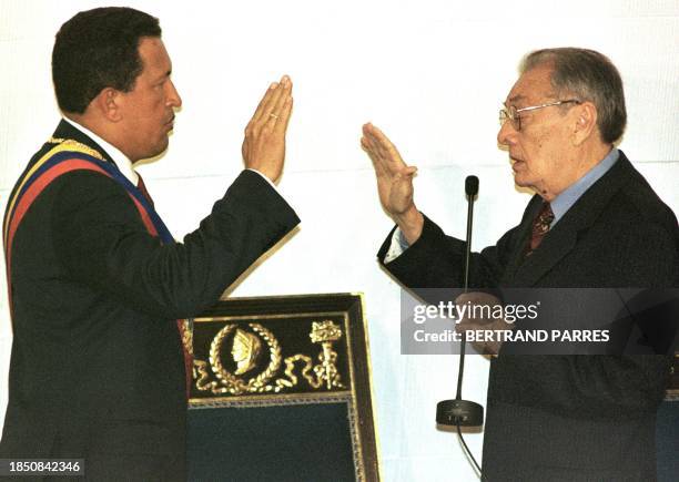 President of the National Assembly Luis Miquelena administers the oath of office to Venezuelan President Hugo Chavez 11 August in Caracas. El...