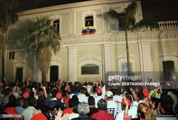 Venezuelan President Hugo Chavez Frias stands above the crowd 22 July 1999 from the palace of Miraflores in Caracas. Varios centenares de seguidores...