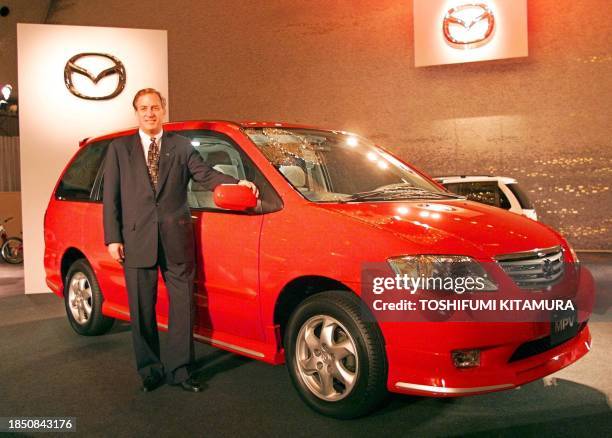 James Miller, president of Mazda, stands beside the company's redesigned minivan, the new MPV during its press preview at a hotel in Tokyo 24 June...