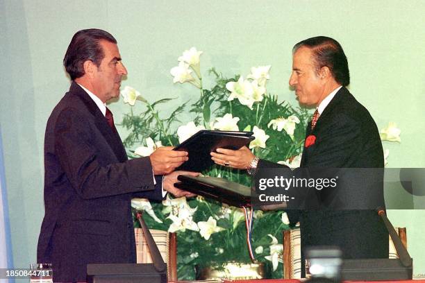 Chilean President Eduardo Frei and Argentina President Carlos Menem exchange agreements on reducing the cost of arms 16 February in Ushuaia,...