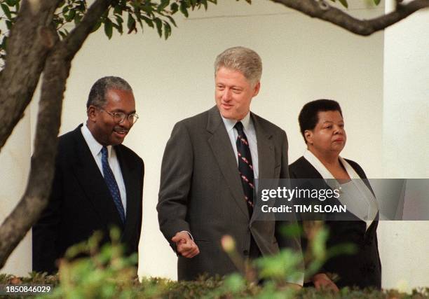 President Bill Clinton walks with Ernest Green and Elizabeth Eckford , two of the original "Little Rock Nine" who integrated Little Rock Central High...