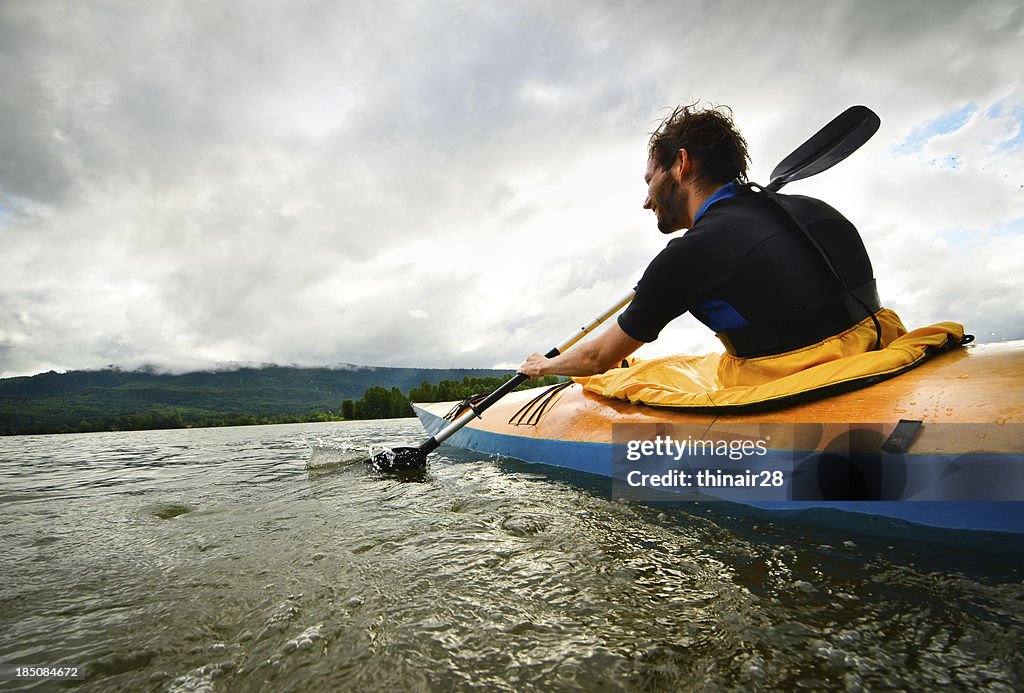 Uomo Pagaiando in kayak in legno