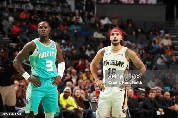 Terry Rozier of the Charlotte Hornets and Jose Alvarado of the New Orleans Pelicans look on during the game on December 15, 2023 at Spectrum Center...