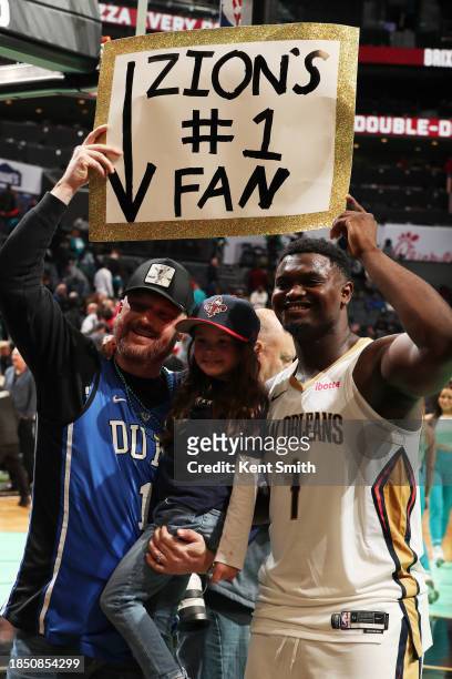 Zion Williamson of the New Orleans Pelicans poses for a photograph with a fan after the game against the Charlotte Hornets on December 15, 2023 at...