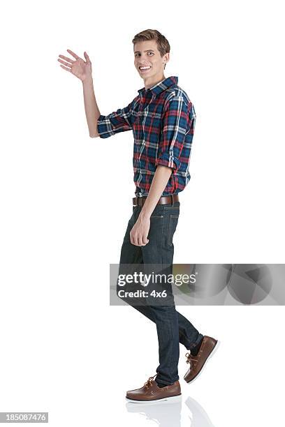 happy young man waving his hand - person waving stock pictures, royalty-free photos & images