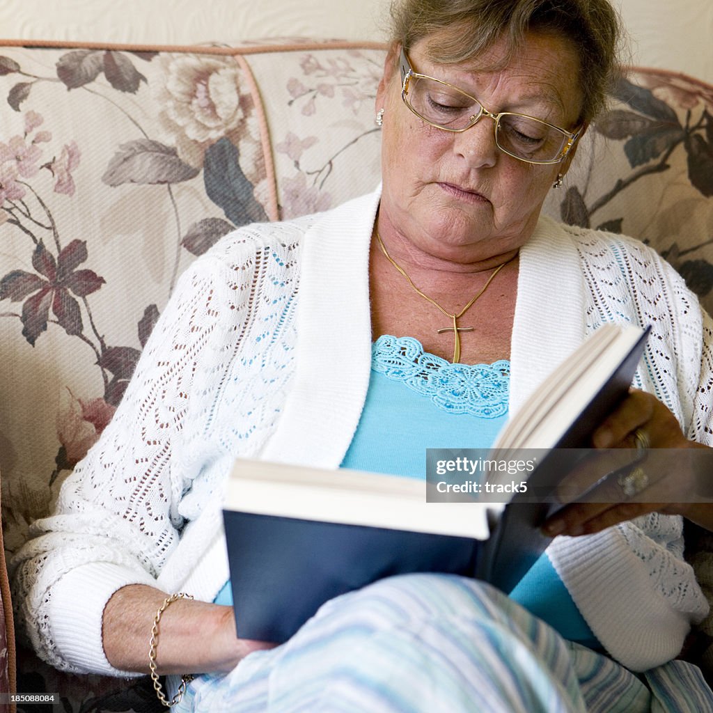Concentrated senior female reading