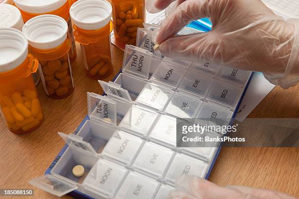 nurse preparing weekly pill organizer - nurse week stock pictures, royalty-free photos & images