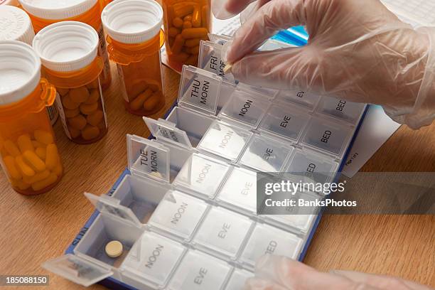 nurse preparing weekly pill organizer - weekly pill box stock pictures, royalty-free photos & images