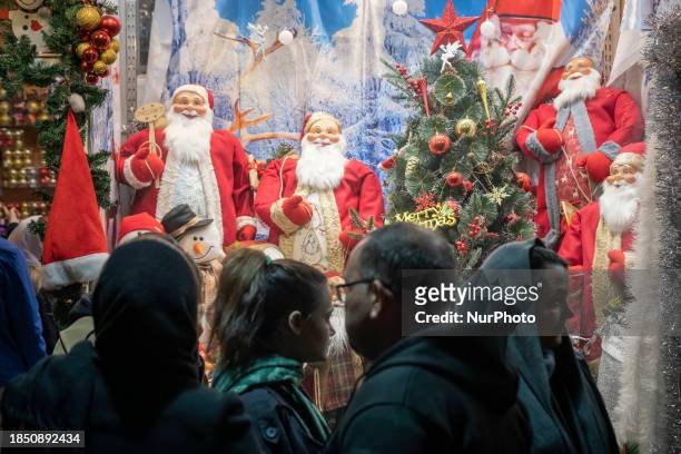 Iranian Christians are walking past a shop window decorated for Christmas shopping in downtown Tehran, Iran, on December 15, 2023. While Iranian...