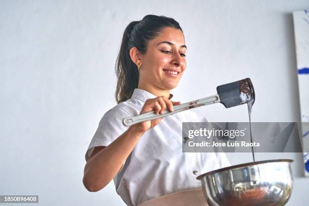 woman creating chocolates with passion - veleiding stockfoto's en -beelden