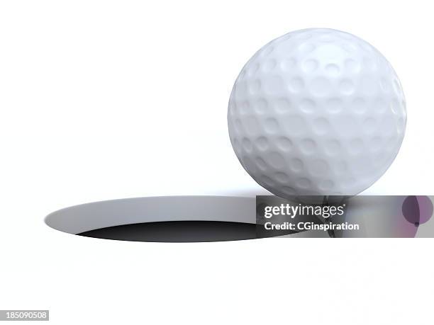 a golf ball on the edge of a hole - golf ball hole stock pictures, royalty-free photos & images