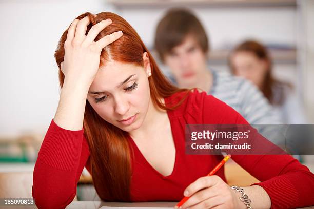 beautiful female college student doing an exam - compete stock pictures, royalty-free photos & images