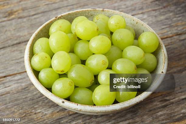 small bowl of organic green grapes on rustic wood - green grape stock pictures, royalty-free photos & images