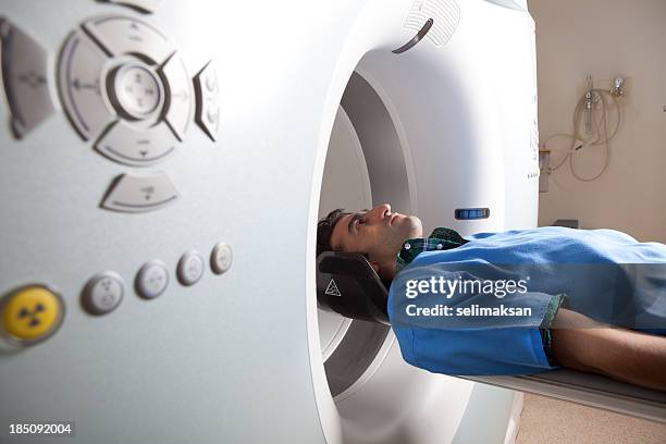 hombre adulto que examen médico a través del escáner tc - pet scan machine fotografías e imágenes de stock