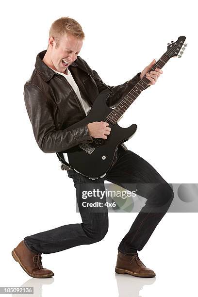 atractiva joven tocando una guitarra - rock star fotografías e imágenes de stock