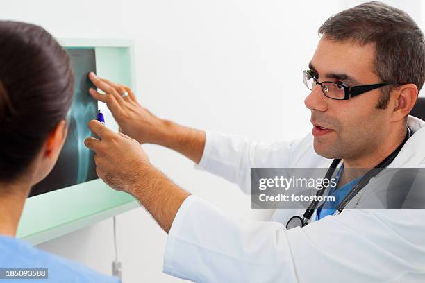 doctors examining x-ray image - x ray pelvis stock pictures, royalty-free photos & images