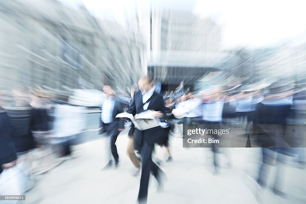 Commuter tráfego, Empresário andando, ler jornal, desfoque de movimento, Londres, Inglaterra