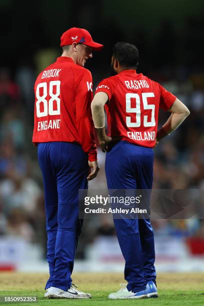 Harry Brook and Adil Rashid of England during the 1st T20 International between West Indies and England at Kensington Oval on December 12, 2023 in...
