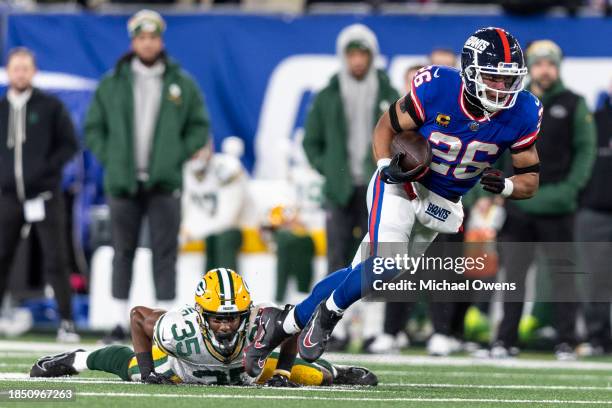 Saquon Barkley of the New York Giants breaks a tackle from Corey Ballentine of the Green Bay Packers and runs with the ball during an NFL football...