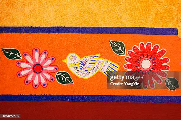 mexican brightly colored, painted stucco wall decorated with bird, flowers - mexican flower pattern stockfoto's en -beelden