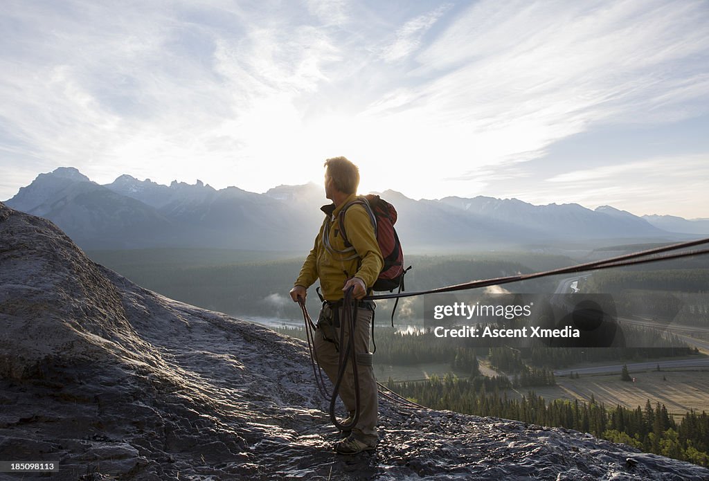 Climber looks over shoulder towards distant mtns