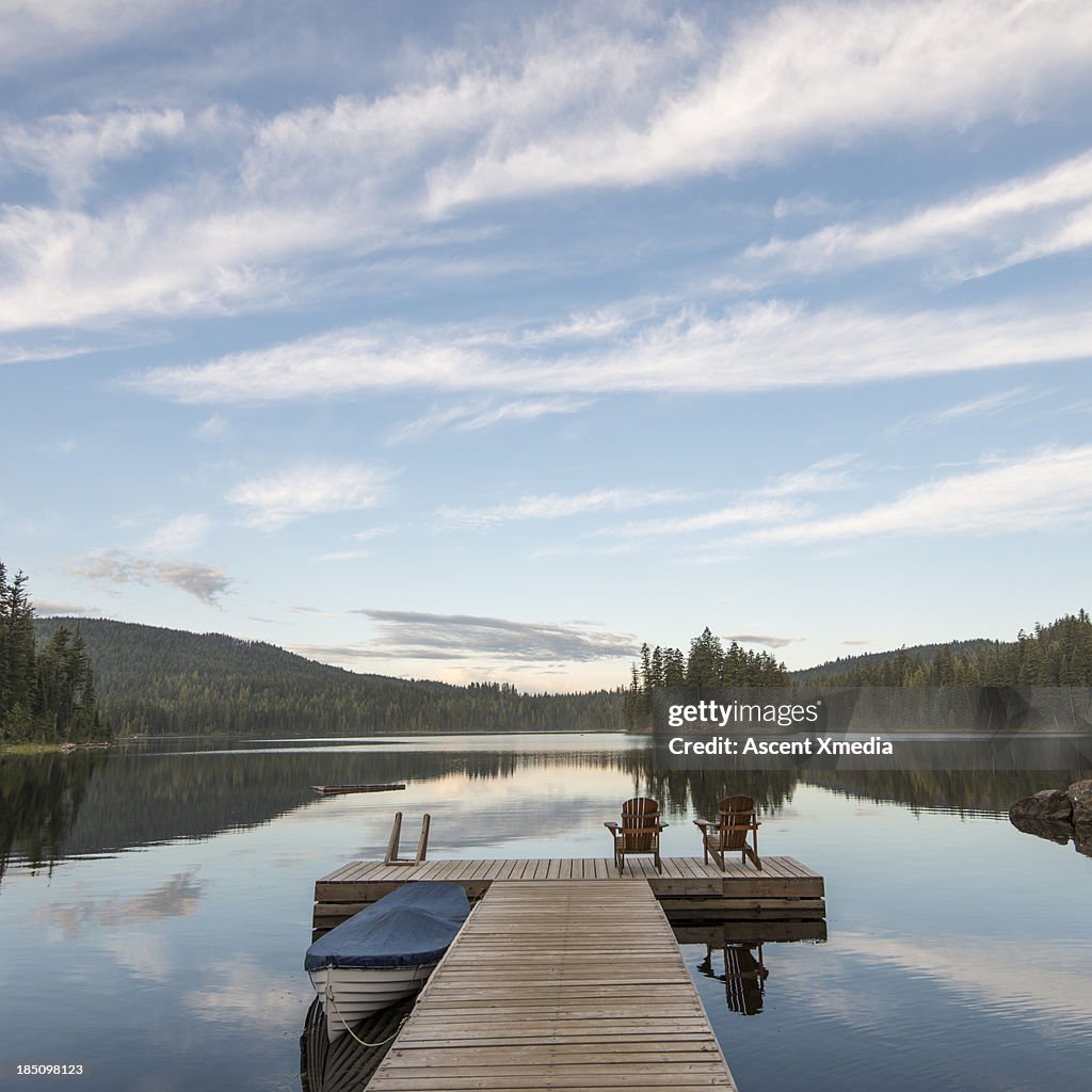 Tranquil scene with lake pier and covered boat