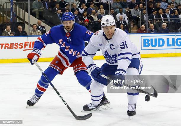 Nick Bonino of the New York Rangers checks John Tavares of the Toronto Maple Leafs d1pat Madison Square Garden on December 12, 2023 in New York City.