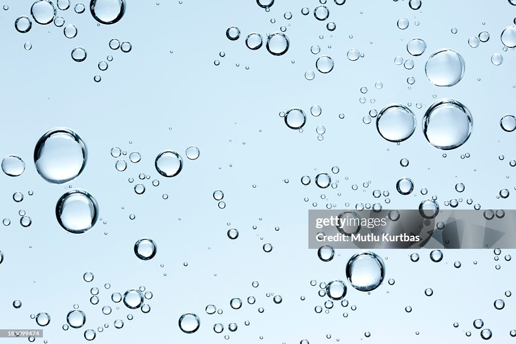 Blasen im klaren Wasser auf blauem Hintergrund