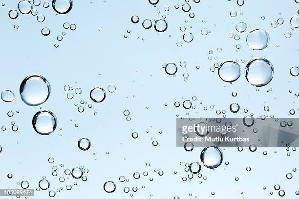 burbujas en el agua clara frescos sobre fondo azul - transparent sphere fotografías e imágenes de stock