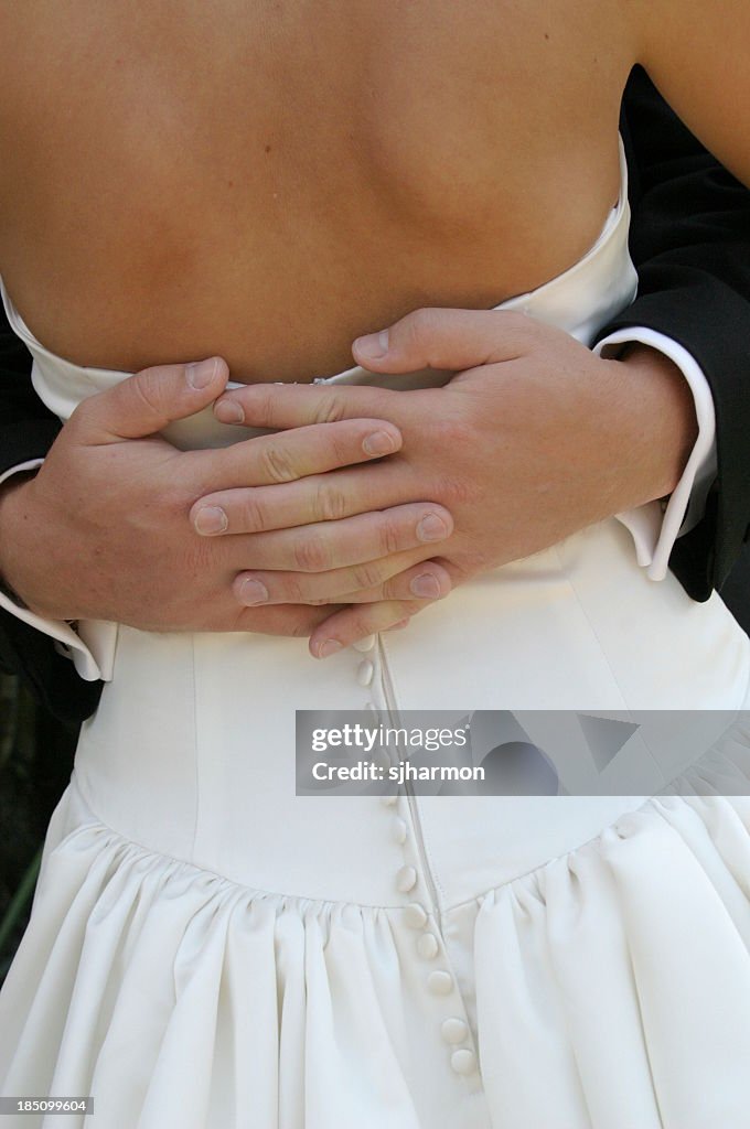 Groom's Hands Clasped Around Bride's Waist Wedding Dress Tux
