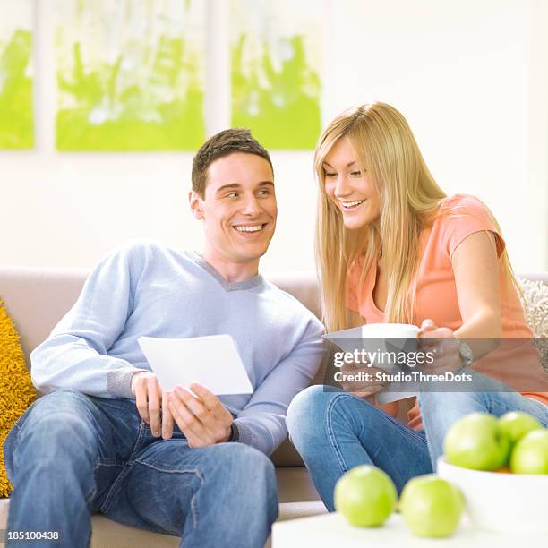 young couple looking at photogrpahs - photogrpahs stock pictures, royalty-free photos & images