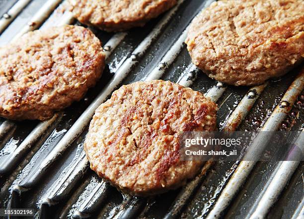 beefburgers zubereitet werden - gusseiserne pfanne stock-fotos und bilder