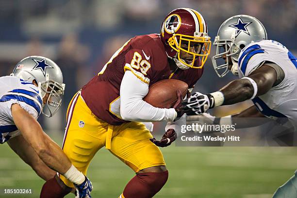 Santana Moss of the Washington Redskins runs the ball against the Dallas Cowboys at AT&T Stadium on October 13, 2013 in Arlington, Texas. The Cowboys...