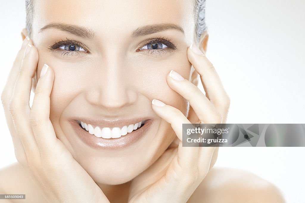 Smiling woman with face in hands