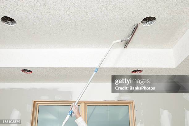 travailleur troweling drywall boue sur un plafond en texture knockdown - plafond photos et images de collection