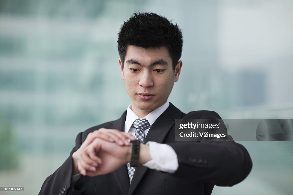 Hombre de negocios mirando a reloj de pulsera