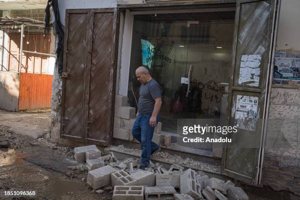 People are around a destroyed house which has walls covered with burn marks due to highly flammable explosives Israeli forces use in attacks at the...