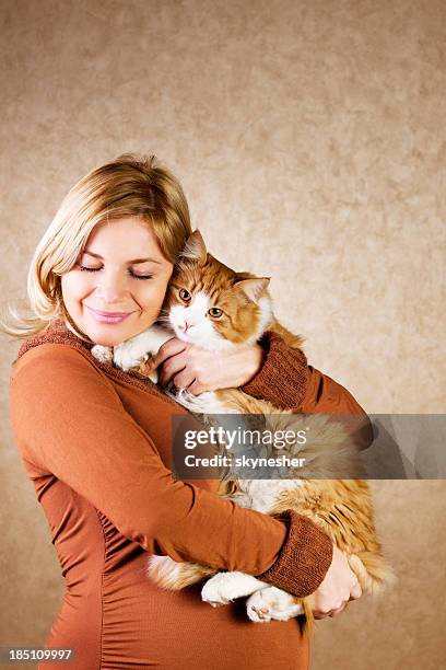 sonriente mujer embarazada sosteniendo su monada cat - animal abdomen fotografías e imágenes de stock