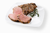 A sliced cooked tenderloin of beef on a white platter