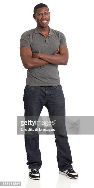 smiling man in gray shirt and blue jeans with arms crossed - grey jeans stock pictures, royalty-free photos & images