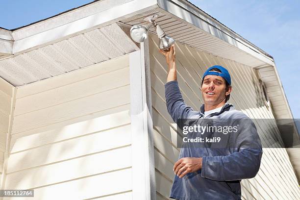 man changing lightbulb - fitting stockfoto's en -beelden