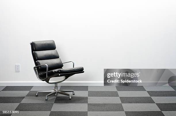 office chair in room with checkered carpeting - leather office chair stock pictures, royalty-free photos & images