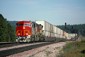 Red locomotive and double stack freight train